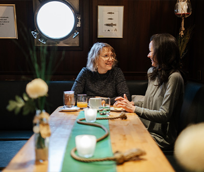 Zwei Frauen unterhalten sich am Frühstückstisch